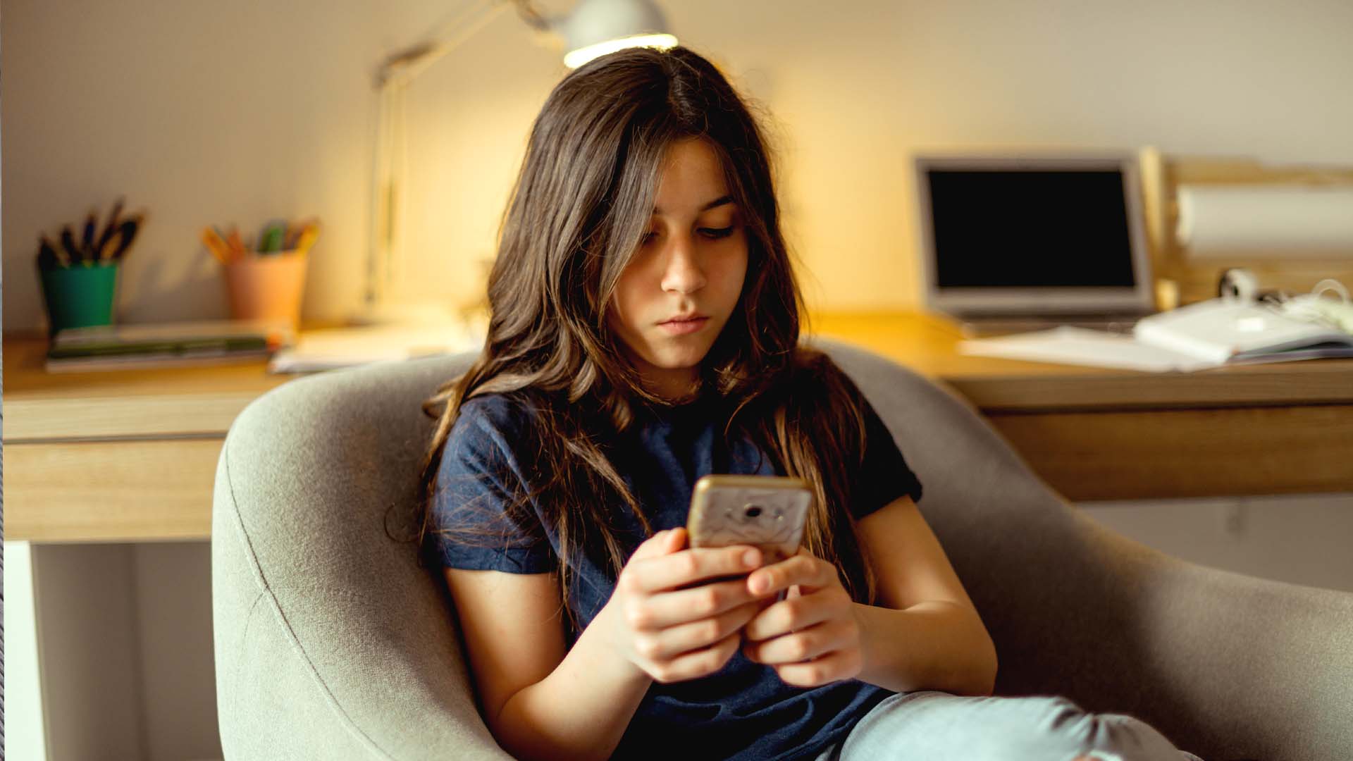Teenager kigger på sin telefon. FOTO: AdobeStock