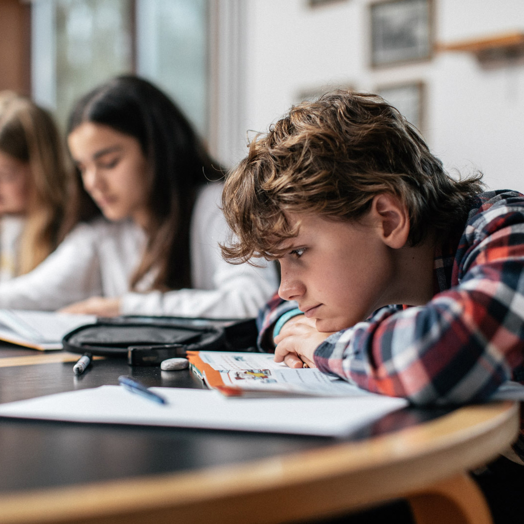 Dreng ligger træt hen over sine skolebøger. FOTO: Jonas Normann (modelfoto)