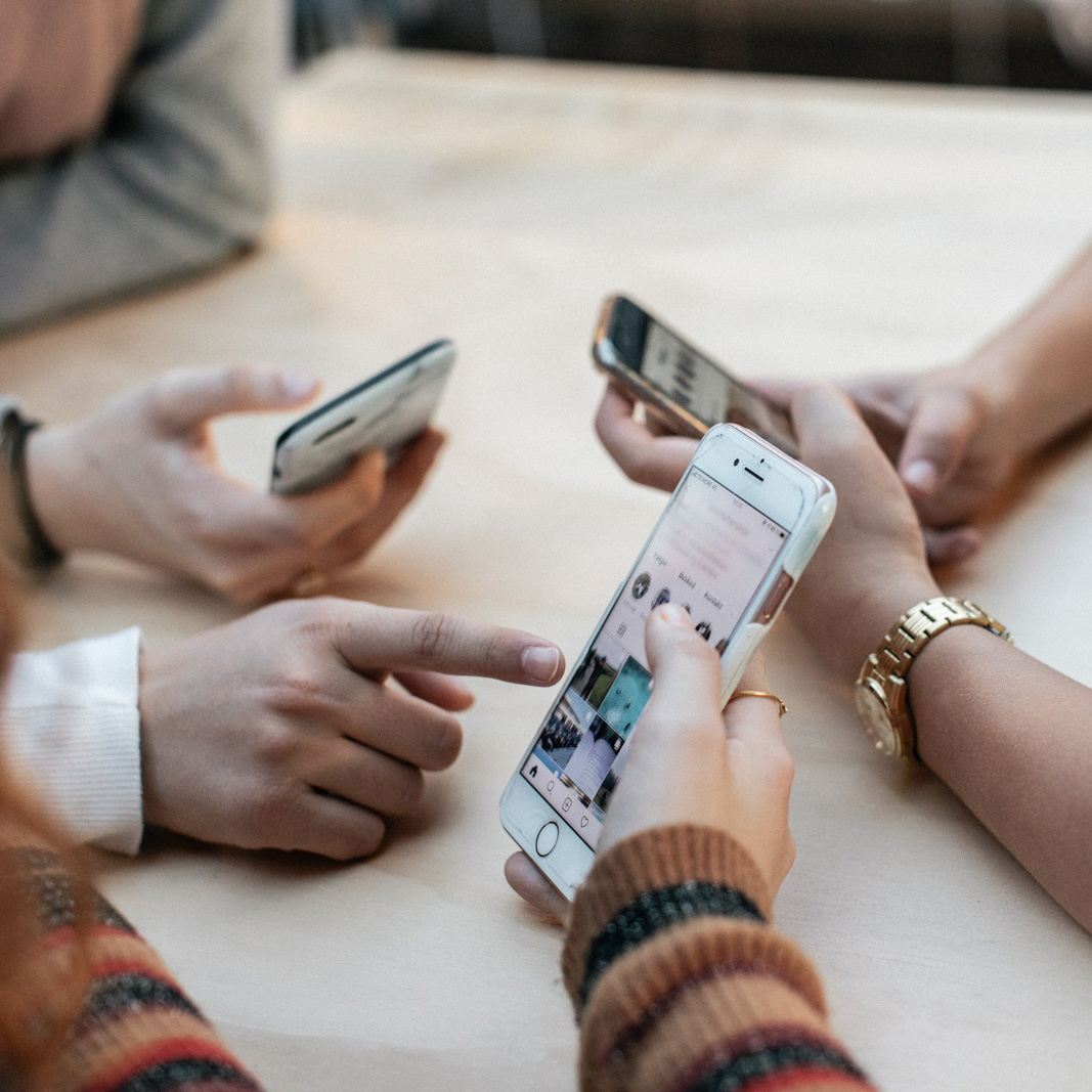 Tre teenagere kigger på deres telefoner sammen. FOTO: Jonas Normann (modelfoto)